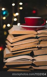books and red cup of coffee with croissant on Christmas background