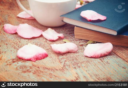 Books, flowers and white cup on wooden table