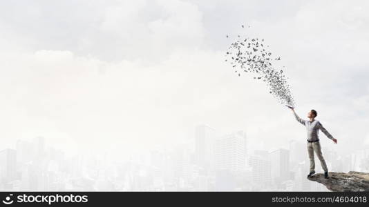 Books let you rise above the rest. Young handsome man in casual reaching hand with book