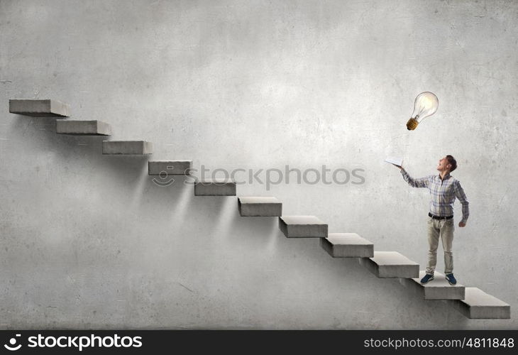 Books let you rise above the rest. Young handsome man in casual reaching hand with book