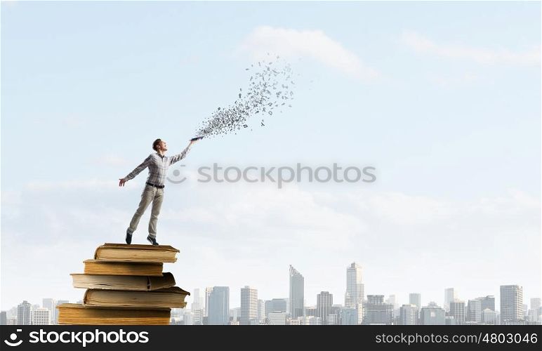 Books let you rise above the rest. Young handsome man on stack reaching hand with book