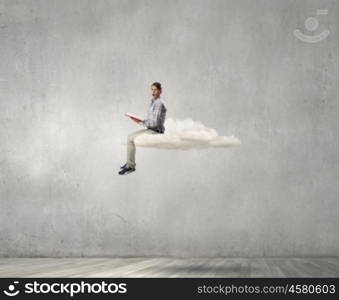 Books let you rise above the rest. Young student man floating on cloud and reading book