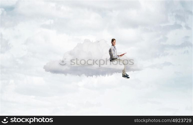 Books let you rise above the rest. Young student man floating on cloud and reading book