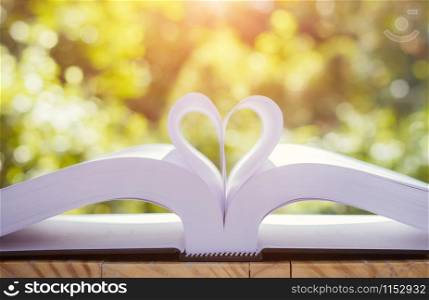 Books on a garden table, heart shaped, bokeh background