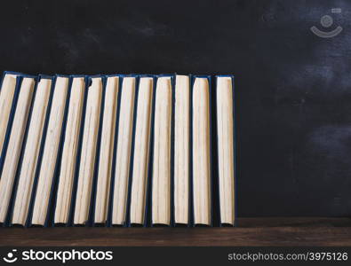 books with blue cover, black background, empty space