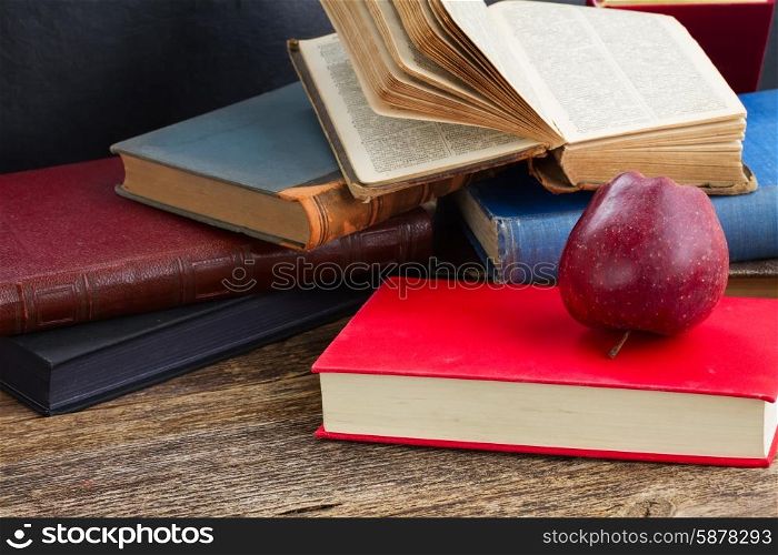 Bookshelf. Pile of books with apple on wooden bookshelf
