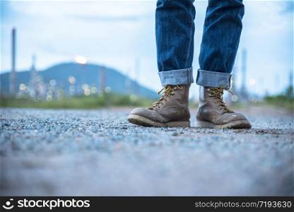 Boots safety worker at construction site. Engineer Wear Jeans And Brown Boots for Worker Security on Background of Refinery. Engineer safety industry fashion foot walking outdoor.