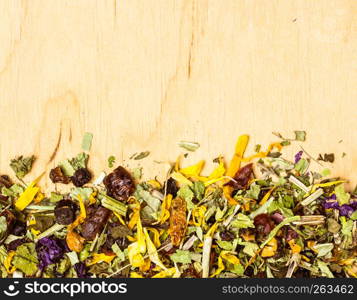 Border frame of assorted natural medical dried herb leaves and flower petals on wooden board with copy space. Assorted natural medical herbs border frame