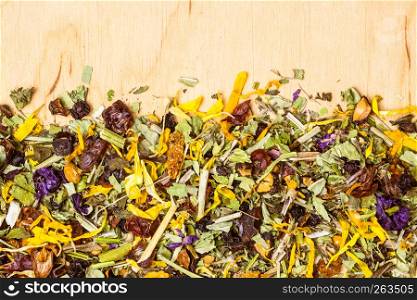 Border frame of assorted natural medical dried herb leaves and flower petals on wooden board with copy space. Assorted natural medical herbs border frame