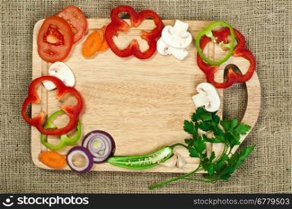 Border from vegetables on kitchen board
