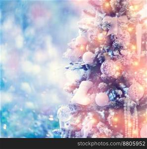 Border of a beautiful glowing Christmas tree over blurry background, fir tree decorated with white stylish baubles, winter holidays spirit