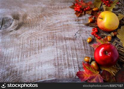 Border of apples, berries and fall leaves on the rustic wooden b. Border of apples, berries and fall leaves on the rustic wooden background. Thanksgiving background with seasonal berries and fruits. Copy space