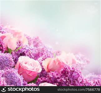 Border of purple Lilac flowers with pink roses over gray background. Lilacand rose flowers