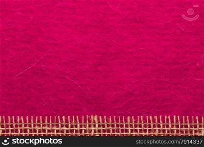 Border or frame formed by rough burlap rope mesh over pink textile background.