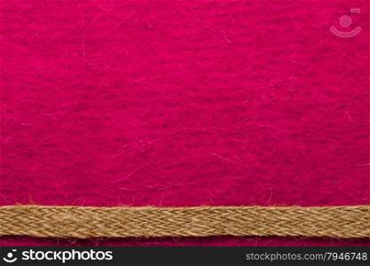 Border or frame formed by rough burlap rope over pink textile background.