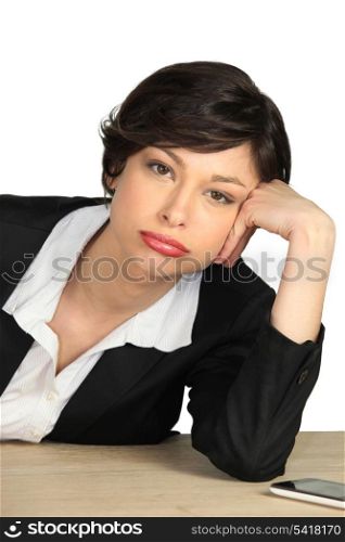 Bored employee leaning on her desk
