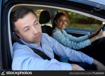 bored instructor teaching woman to drive