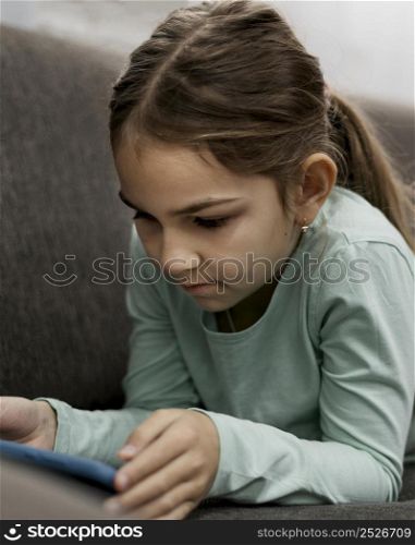bored little girl playing smartphone home