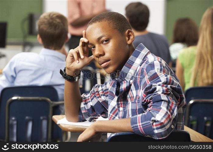 Bored Male Teenage Pupil In Classroom