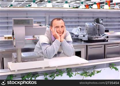 bored seller in shop with empty shelves and counters