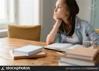 Bored student girl sitting home living room looking away read book