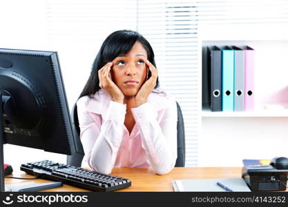 Bored unhappy young black business woman at desk in office