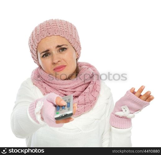 Bored woman in knit winter clothing using TV remote control