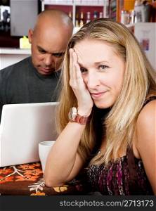 Bored woman with man on laptop computer