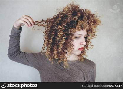 Bored young woman touching her hair