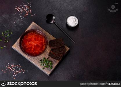 Borscht - traditional Ukraine soup made of beetroot, tomato, cabbage, carrot and beef. Traditional Ukrainian borsch. Bowl of red beet root soup borsch with green onion