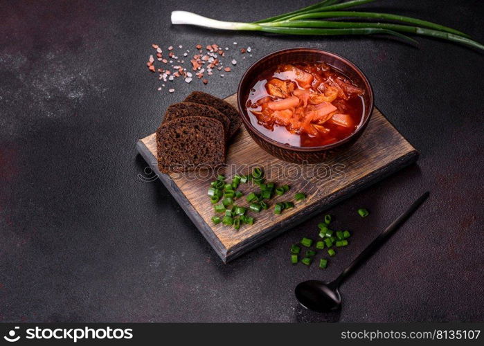 Borscht - traditional Ukraine soup made of beetroot, tomato, cabbage, carrot and beef. Traditional Ukrainian borsch. Bowl of red beet root soup borsch with green onion