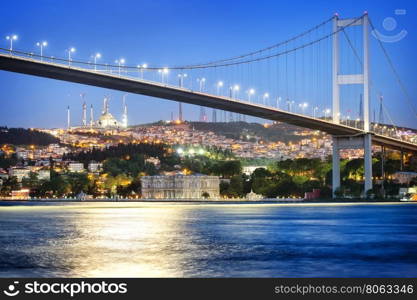 Bosphorus Bridge at night with moon path. Istanbul, Turkey.