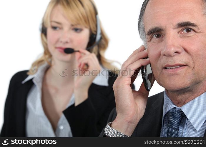 Boss and assistant making calls to customers