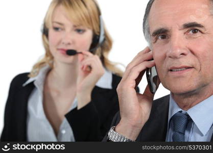 Boss and assistant making calls to customers