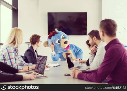 Boss dresed as teddy bear having fun with bussines people in modern corporate office