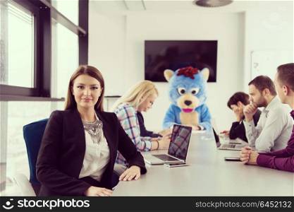 Boss dresed as teddy bear having fun with bussines people in modern corporate office