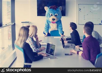 Boss dresed as teddy bear having fun with bussines people in modern corporate office