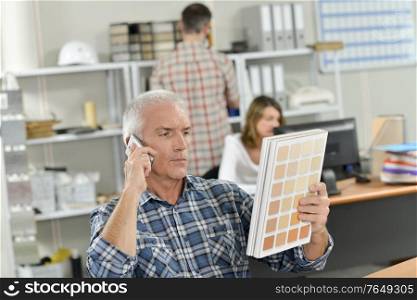 Boss on the phone holding a colour chart