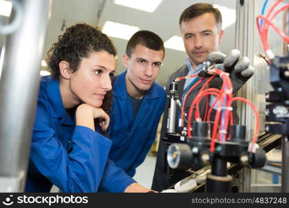 boss showing workers a new machine