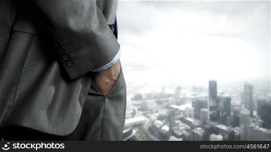 Bossy businessman. Close up of businessman standing on top viewing at city