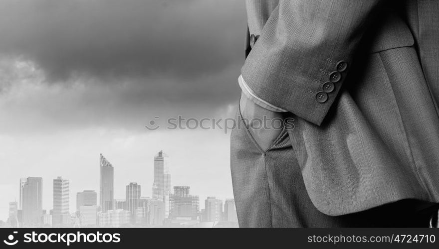 Bossy businessman. Close up of businessman standing on top viewing at city