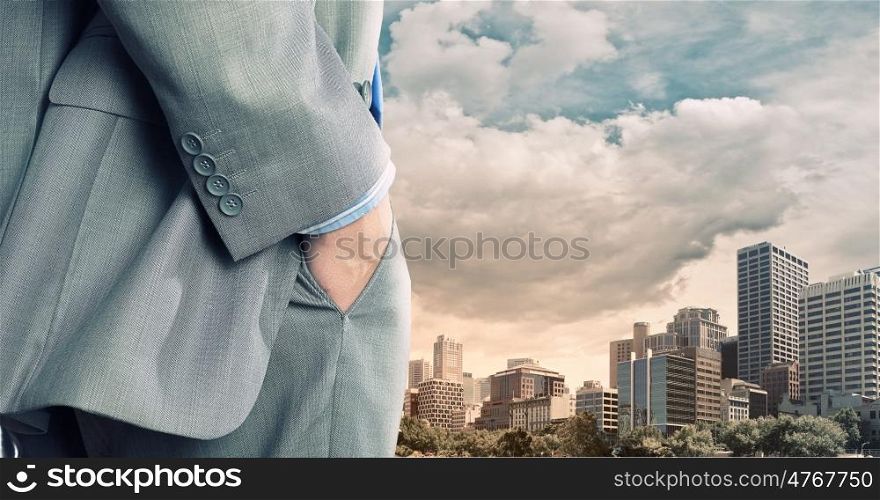 Bossy businessman. Close up of businessman standing on top viewing at city