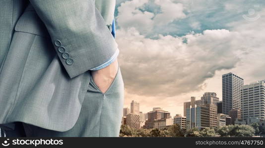 Bossy businessman. Close up of businessman standing on top viewing at city