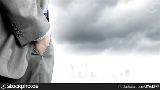 Bossy businessman. Close up of confident businessman with hands in pockets