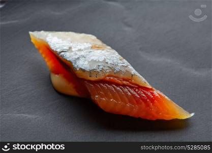 Bota sardine macro slice closeup on black slate dish