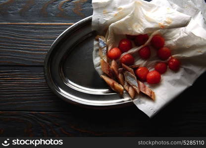 Bota sardine with osmotized tomatoes on steel tray