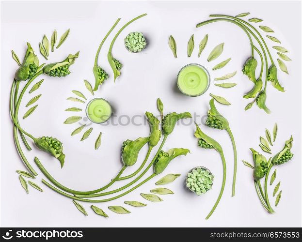 Botanical flat lay with leaves , green flowers and candles on white background, top view. Spa, wellness, beauty, relaxing and vegan skin care concept