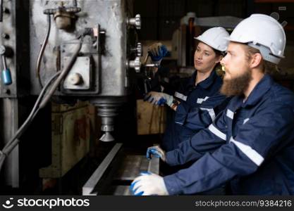 Both of mechanical engineers are checking the working condition of an old machine that has been used for some time. In a factory where natural light shines onto the workplace