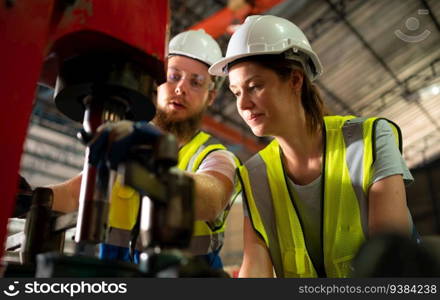 Both of mechanical engineers are checking the working condition of the new machine after completing the installation