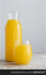 Bottle and glass of orange juice made of fresh oranges isolated over white background. Full glass of vitaminized drink. Citrus beverage